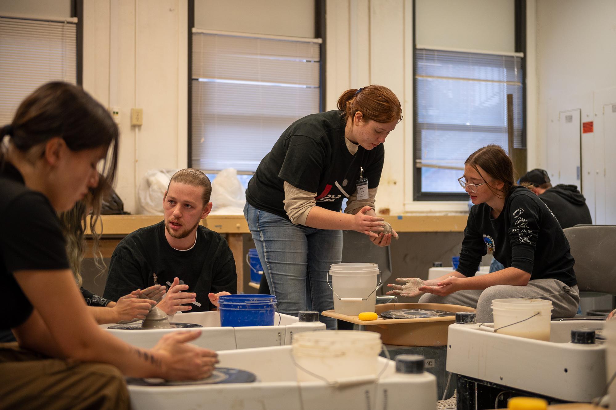 Chadron State College Art majors assist students during a ceramics workshop at Art Day, Nov. 5, 2024 (Photo by Sydney Brown/Chadron State College)